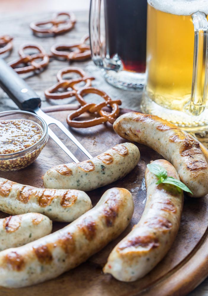 bratwurst with beer and pretzels on table